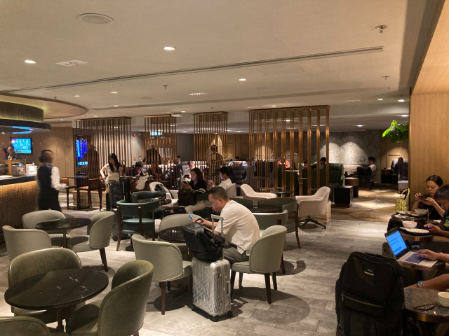 Past the bar is a transparent partition and more lounge chairs and couches Past the bar is a transparent partition and more lounge chairs and couches