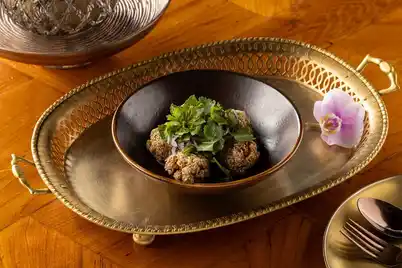 Banyan Tree Krabi Retains Two MICHELIN Keys, Strengthening Thailand’s Luxury Edge 3 The classic Thai recipe of laab gai thod is prepared tableside by the Saffron team