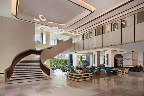 Lobby design of Iconic Marjorie Hotel Penang, where the Loom & Leafs Lounge is the centre, and a grand staircase leading up the TIFFIN HALL all-day-dining restaurant.