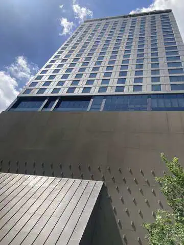 Exterior view of KROMO Bangkok, Curio Collection by Hilton, seen from ground level looking up the 28-storey building