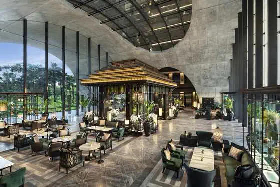 Sunlit lobby with soaring glass atrium at Sindhorn Kempinski Hotel Bangkok