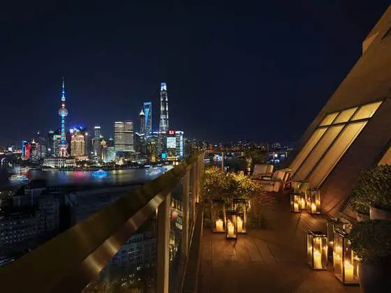 The Terrace Suite at The Shanghai EDITION at night, featuring a stylish outdoor terrace and illuminated city views