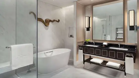 Marble bathroom with freestanding bathtub and walk-in rain shower at Sindhorn Kempinski Hotel Bangkok