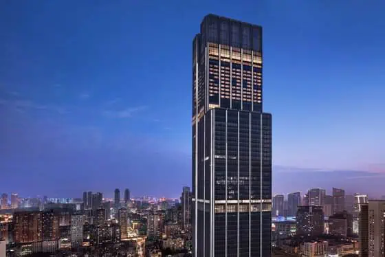 The Ritz-Carlton, Wuhan exterior illuminated at night with the city skyline in the background
