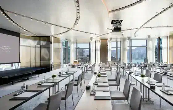 Meeting room at Kimpton Tsim Sha Tsui Hong Kong with conference tables and chairs arranged for a business meeting