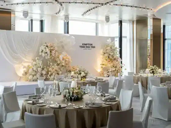 Ballroom at Kimpton Tsim Sha Tsui Hong Kong arranged for a wedding with banquet tables and wedding décor