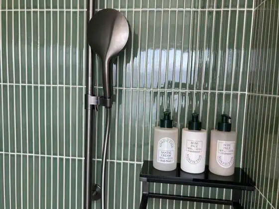 Rose Pale shampoo and conditioner bottles in the walk-in shower at Kimpton Tsim Sha Tsui Hong Kong.