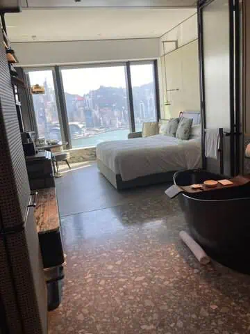 King Premium Central Harbour View room at Kimpton Tsim Sha Tsui Hong Kong, featuring views of Victoria Harbour.