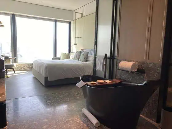 Deep bathtub in the bathroom of a King Premium Central Harbour View room at Kimpton Tsim Sha Tsui Hong Kong.